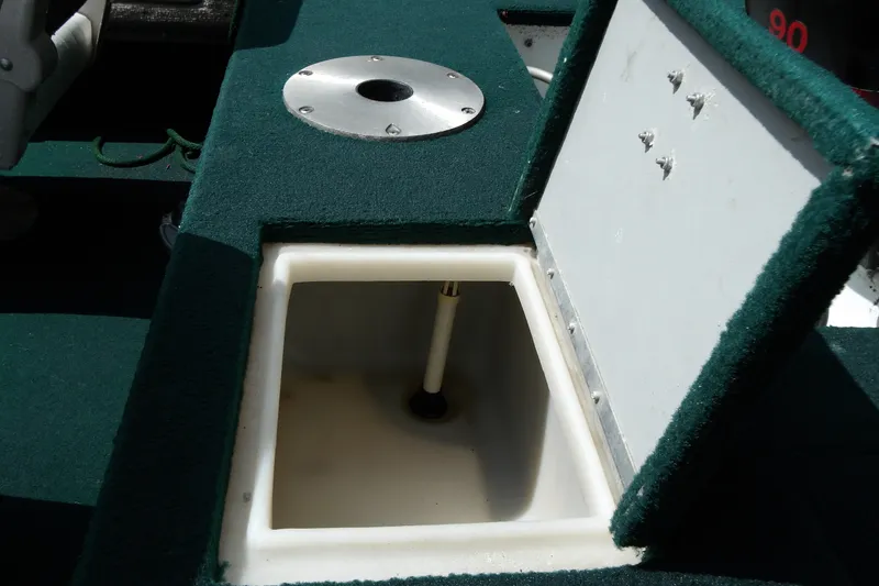 Slide: The Image of Open storage compartment on 2000 Starcraft C-Star 170 DC boat with green carpeted surface. - 16