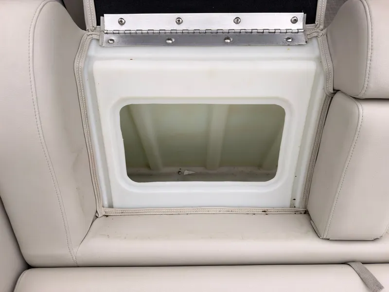 Slide: The Image of An open storage compartment in a boat seat with light gray upholstery. - 48