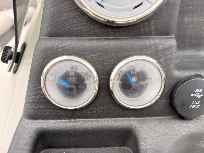 Slide: The Image of Close-up of two analog gauges and a USB/AUX input on a boat. - 31