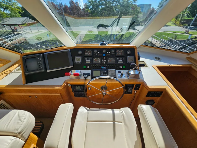 Slide: The Image of The image shows the helm of a 1991 Hatteras 70 Cockpit Motor Yacht with modern instruments. - 11