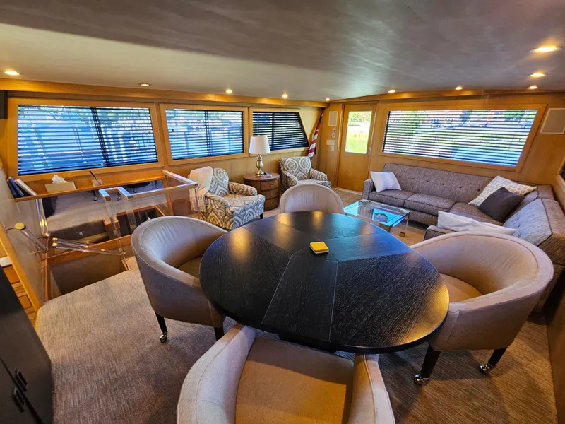 Slide: The Image of Interior of a 1991 Hatteras 70 Cockpit Motor Yacht with elegant seating and wood accents. - 16