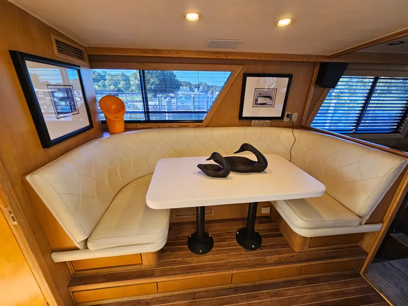 Slide: The Image of Interior of a 1991 Hatteras 70 Cockpit Motor Yacht with an elegant seating area and table. - 15