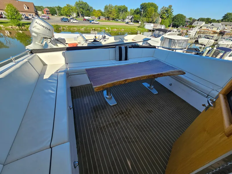 Slide: The Image of The image shows the cockpit of a 1991 Hatteras 70 Cockpit Motor Yacht with a wooden table. - 12