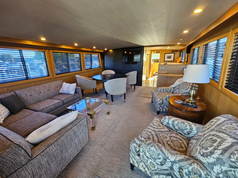 Slide: The Image of Interior of a 1991 Hatteras 70 Cockpit Motor Yacht with elegant seating area and dining table. - 2