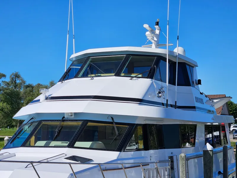 Slide: The Image of A 1991 Hatteras 70 Cockpit Motor Yacht docked, featuring a sleek, modern design. - 9