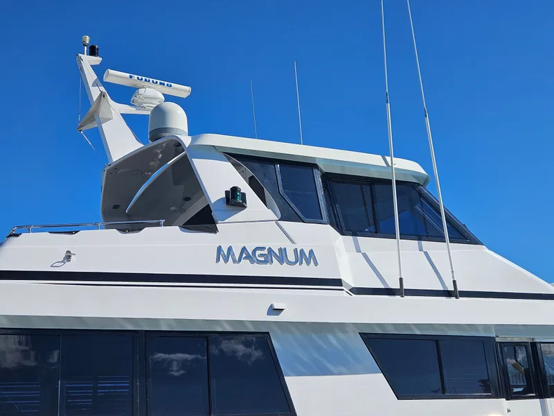 Slide: The Image of The 1991 Hatteras 70 Cockpit Motor Yacht features a sleek white design with blue accents. - 7