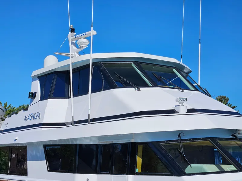 Slide: The Image of The 1991 Hatteras 70 Cockpit Motor Yacht features a sleek design with large windows and antennas. - 8