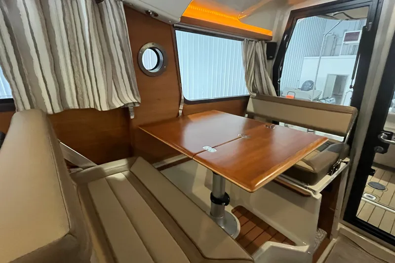 Slide: The Image of Interior of 2022 Ranger Tugs R-27, featuring a cozy dining area with wood table. - 17