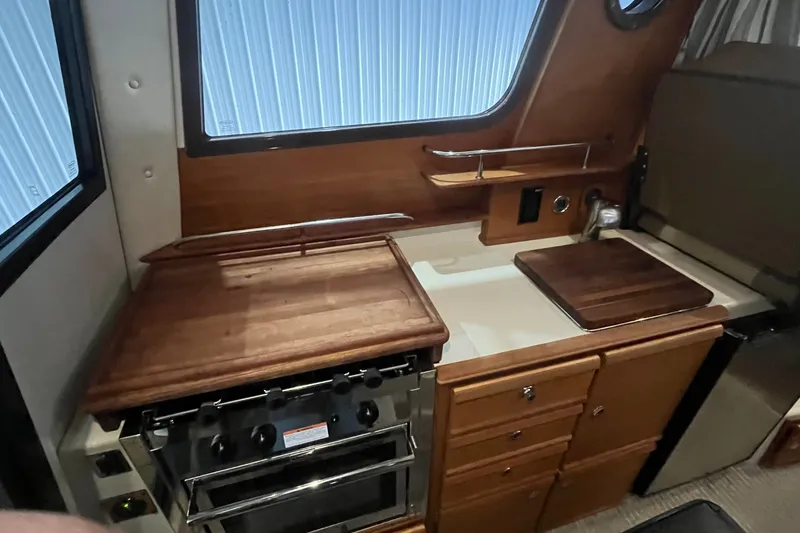 Slide: The Image of Interior of 2022 Ranger Tugs R-27 boat kitchen with stove and wooden countertops. - 13