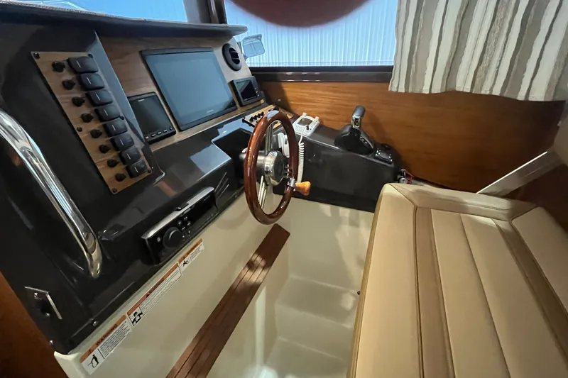 Slide: The Image of Interior helm of 2022 Ranger Tugs R-27 with steering wheel and control panel. - 10