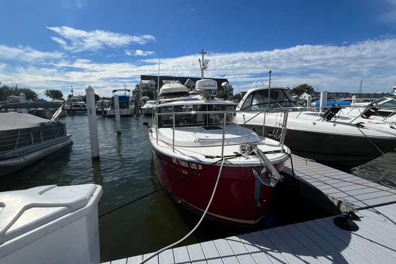 Slide: The Image of 2022 Ranger Tugs R-27 docked at marina under blue sky. - 2