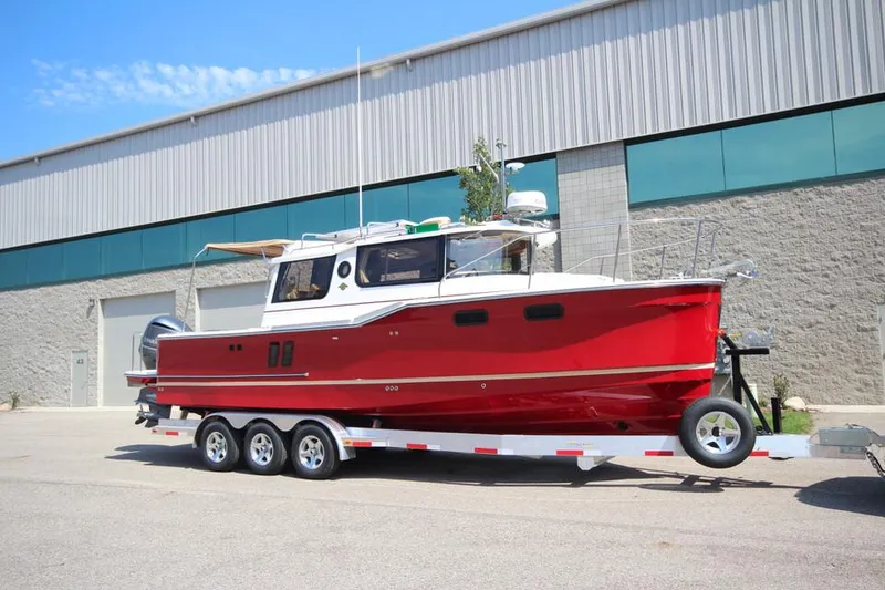 Slide: The Image of Ein rotes Ranger Tugs R-27 Boot von 2022 auf einem Anhänger vor einem Gebäude. - 7