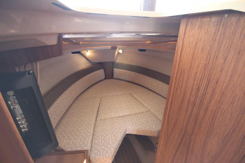 Slide: The Image of Die Kabine der Ranger Tugs R-27 von 2022 zeigt ein gemütliches Bett mit Holzverkleidung. - 43
