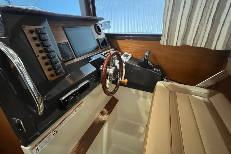 Slide: The Image of Interior helm of 2022 Ranger Tugs R-27 with modern controls and steering wheel. - 16