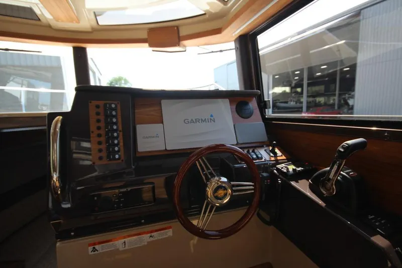Slide: The Image of Das Cockpit der Ranger Tugs R-27 von 2022 mit einem Garmin-Navigationssystem und einem Holzlenkrad. - 38