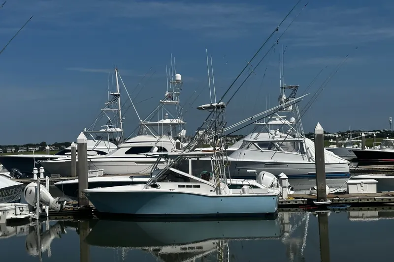 The Image of 1996 Carolina Classic 28 boat docked in a marina with other vessels. - 1