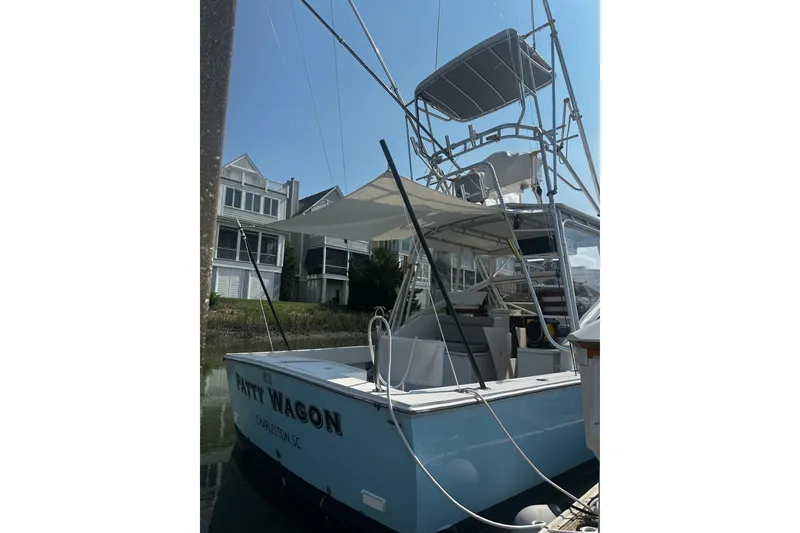 Slide: The Image of 1996 Carolina Classic 28 boat docked, featuring a tower and shaded deck area. - 6
