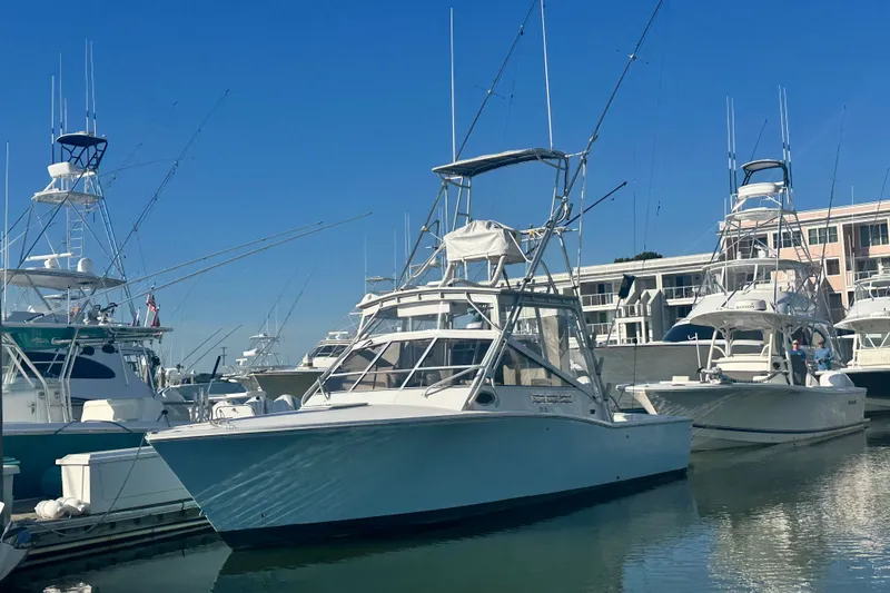 Slide: The Image of 1996 Carolina Classic 28 boat docked in a marina under clear blue skies. - 4