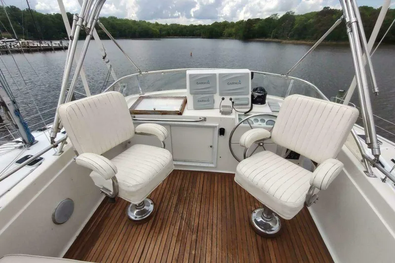 Slide: The Image of Flybridge of 1996 Grand Banks Eastbay 40 with white captain chairs and wooden deck. - 18
