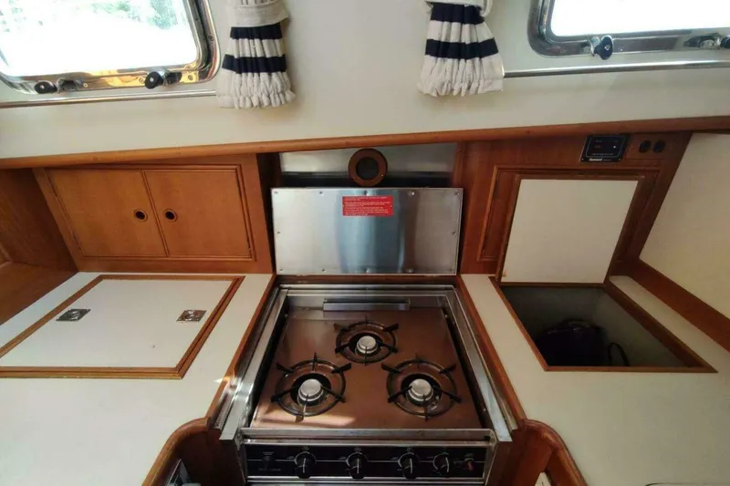 Slide: The Image of Galley kitchen in 1996 Grand Banks Eastbay 40 Flybridge with gas stove and wooden cabinetry. - 56