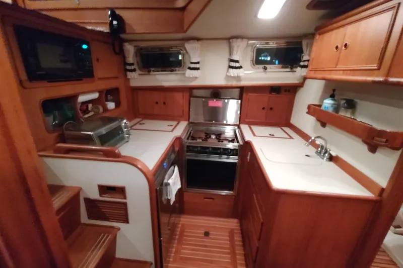 Slide: The Image of 1996 Grand Banks Eastbay 40 Flybridge galley with wood cabinetry and modern appliances. - 52