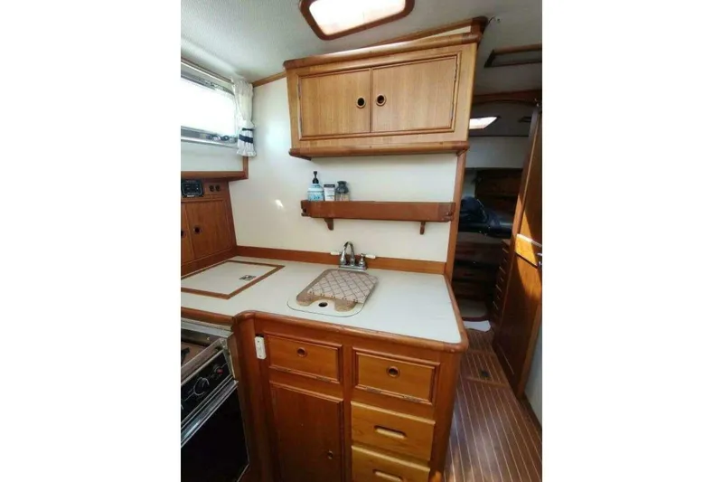 Slide: The Image of 1996 Grand Banks Eastbay 40 Flybridge kitchen with wooden cabinets and countertop. - 57