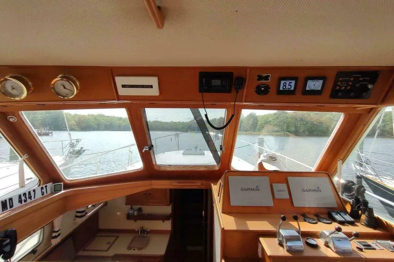 Slide: The Image of 1996 Grand Banks Eastbay 40 Flybridge helm with Garmin navigation, overlooking serene waters. - 27