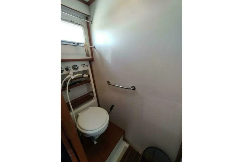 Slide: The Image of Bathroom interior of 1996 Grand Banks Eastbay 40 Flybridge yacht, featuring a compact toilet. - 64