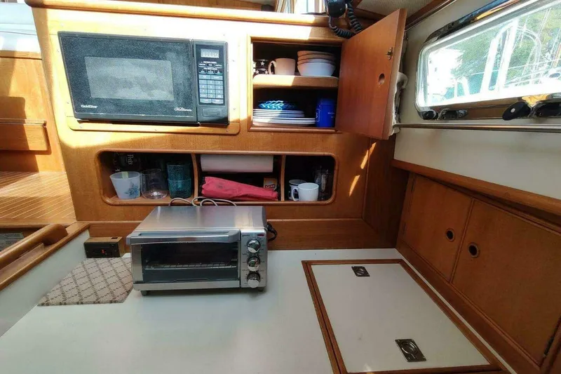 Slide: The Image of 1996 Grand Banks Eastbay 40 Flybridge galley with microwave, toaster oven, and wooden cabinetry. - 51