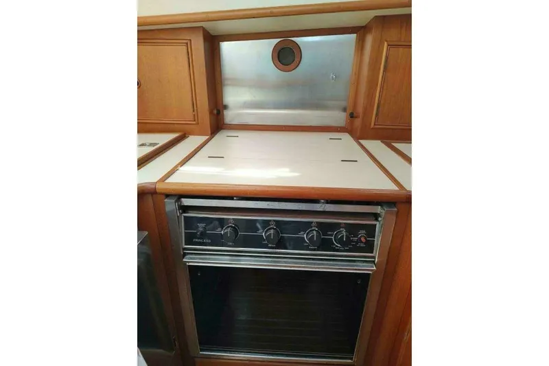 Slide: The Image of 1996 Grand Banks Eastbay 40 Flybridge kitchen with stove and wooden cabinetry. - 54