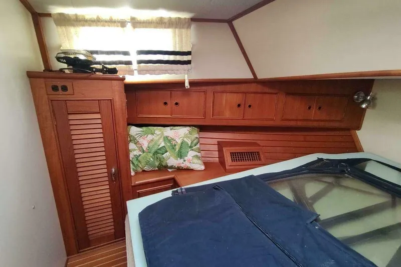 Slide: The Image of 1996 Grand Banks Eastbay 40 Flybridge cabin with wooden cabinetry and tropical-themed cushion. - 69