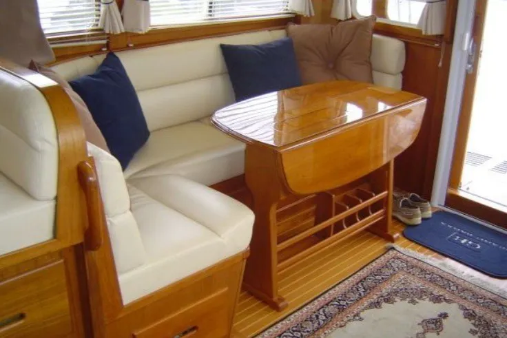 Slide: The Image of Interior of 1996 Grand Banks 40 Eastbay FB with wooden table and cushioned seating. - 40