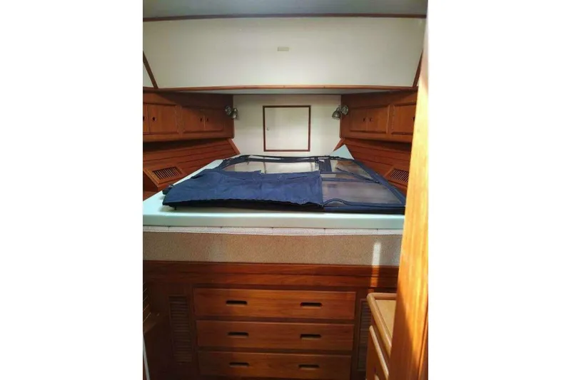 Slide: The Image of 1996 Grand Banks Eastbay 40 Flybridge cabin interior with wooden cabinetry and bed. - 70