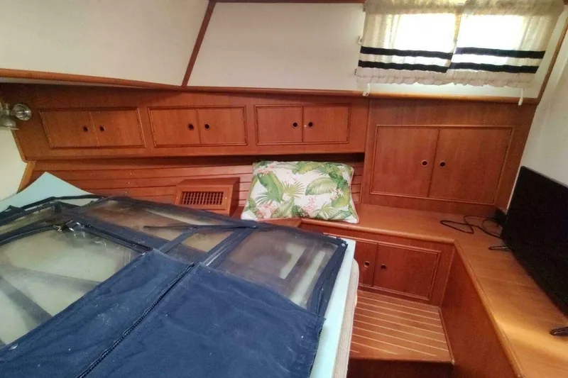 Slide: The Image of 1996 Grand Banks Eastbay 40 Flybridge cabin with wooden cabinetry and tropical-themed pillow. - 68