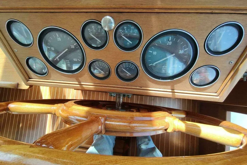 Slide: The Image of 1996 Grand Banks Eastbay 40 Flybridge dashboard with wooden steering wheel and gauges. - 34