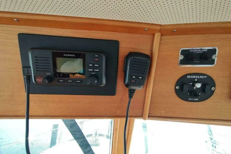 Slide: The Image of 1996 Grand Banks Eastbay 40 Flybridge dashboard with Garmin radio and searchlight controls. - 29