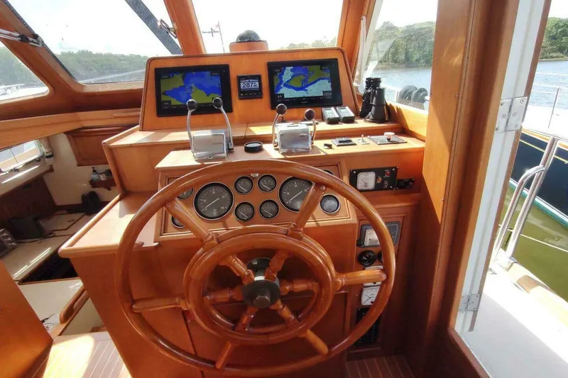 Slide: The Image of 1996 Grand Banks Eastbay 40 Flybridge helm with wooden wheel and navigation screens. - 32