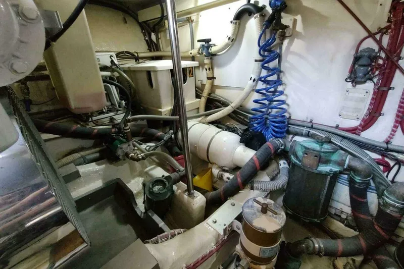 Slide: The Image of Engine room of 1996 Grand Banks Eastbay 40 Flybridge with complex piping and machinery. - 90