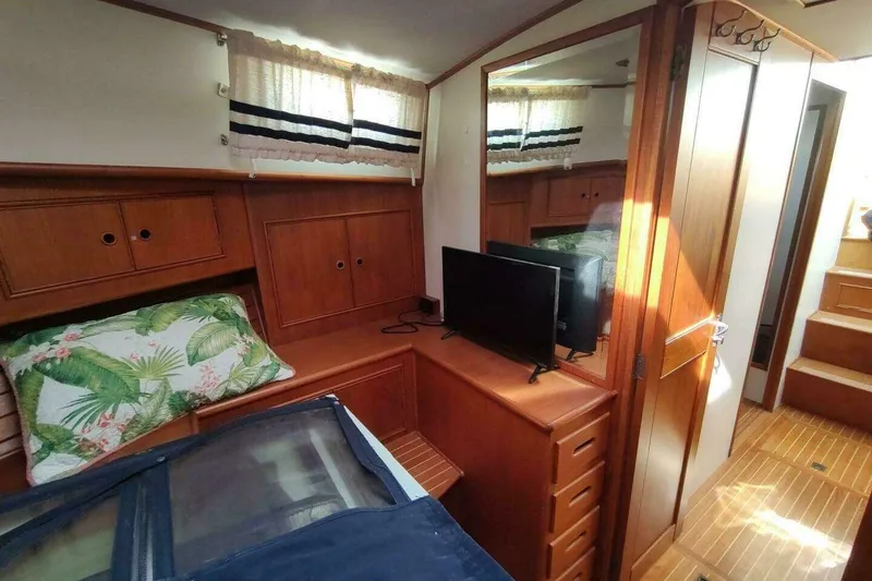 Slide: The Image of Cozy cabin interior of 1996 Grand Banks Eastbay 40 Flybridge with wood finish and TV. - 67