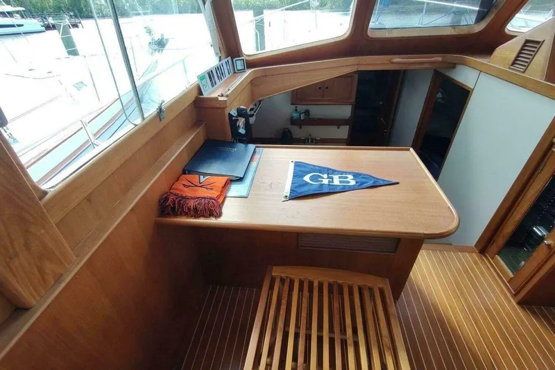 Slide: The Image of Interior of 1996 Grand Banks Eastbay 40 Flybridge with wooden table and nautical decor. - 48