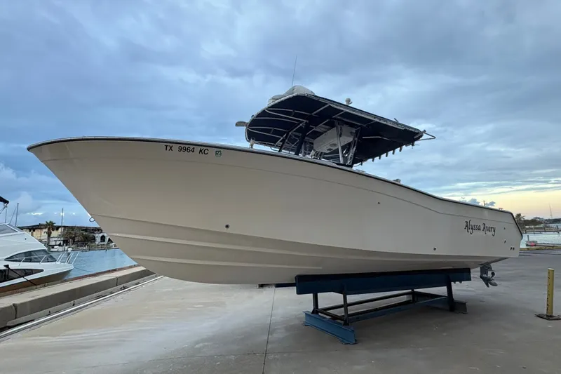 The Image of 2004 Grady White Bimini 306 boat on stand, dockside view, overcast sky. - 0