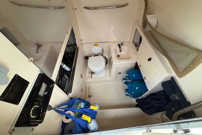 Slide: The Image of Interior of a 2004 Grady White Bimini 306 boat, featuring a compact bathroom setup. - 17