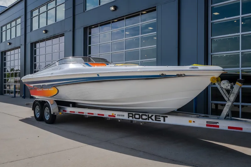 Slide: The Image of 2012 Nautical NRG 30 boat on a Rocket trailer outside a modern building. - 7