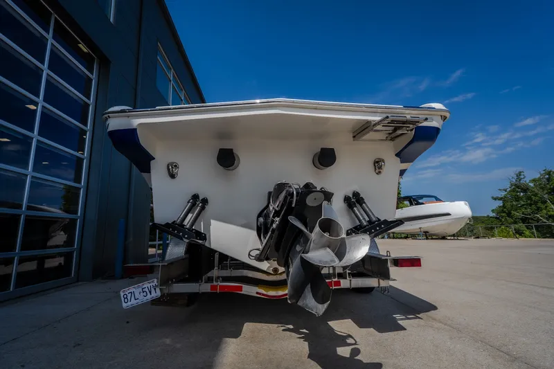 Slide: The Image of Rear view of a 2012 Nautical NRG 30 boat on a trailer, under clear blue sky. - 51