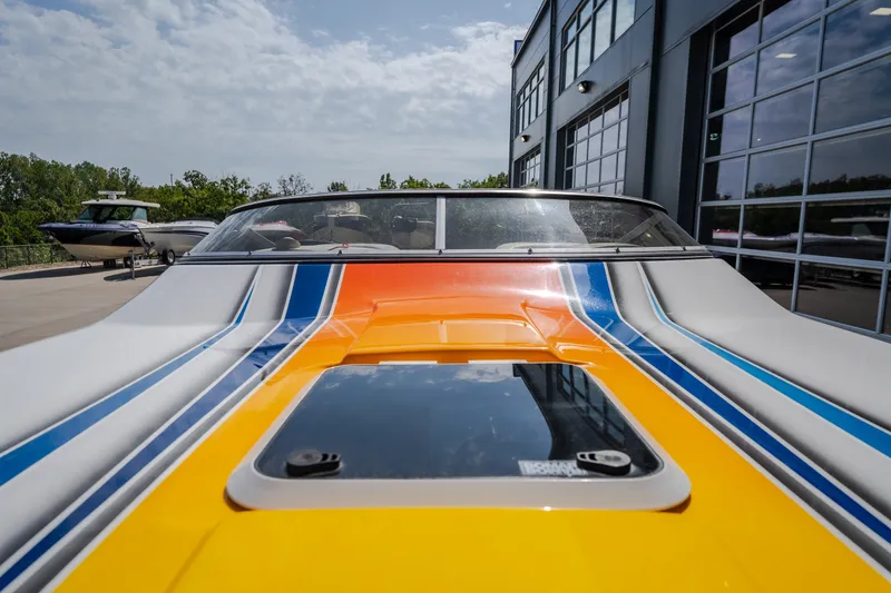 Slide: The Image of Colorful Nautical NRG 30 boat from 2012, parked near a modern building. - 29