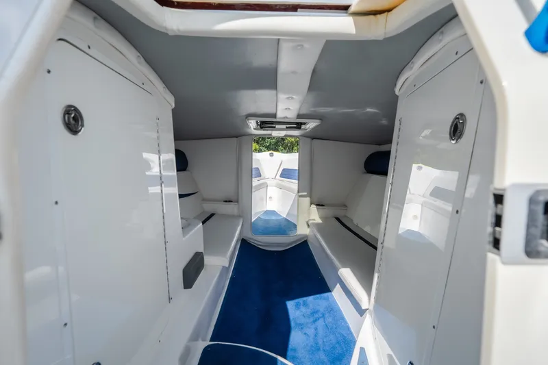 Slide: The Image of Interior of 2012 Nautical NRG 30 boat, featuring sleek white design and blue carpet. - 23