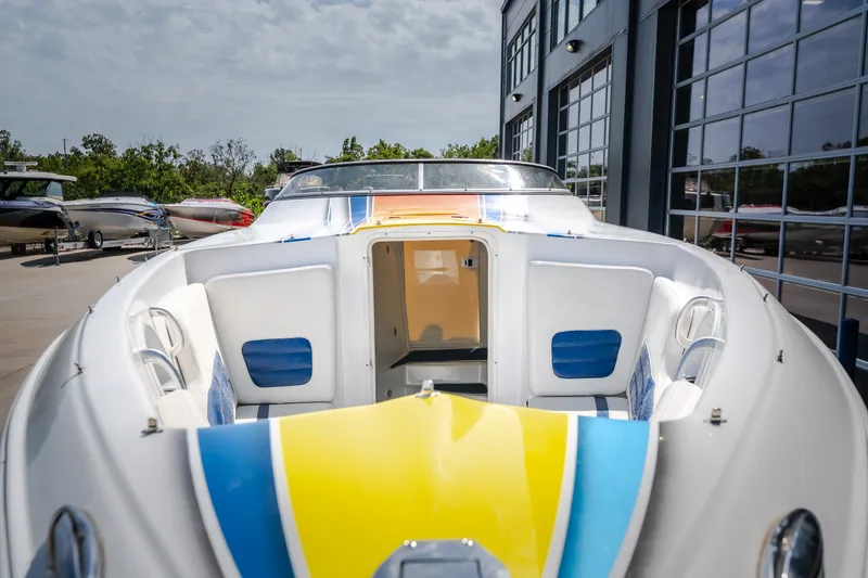 Slide: The Image of 2012 Nautical NRG 30 boat with colorful deck, docked near modern building. - 27