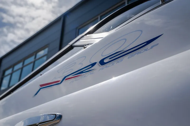 Slide: The Image of Close-up of a 2012 Nautical NRG 30 boat with sleek design and logo. - 9