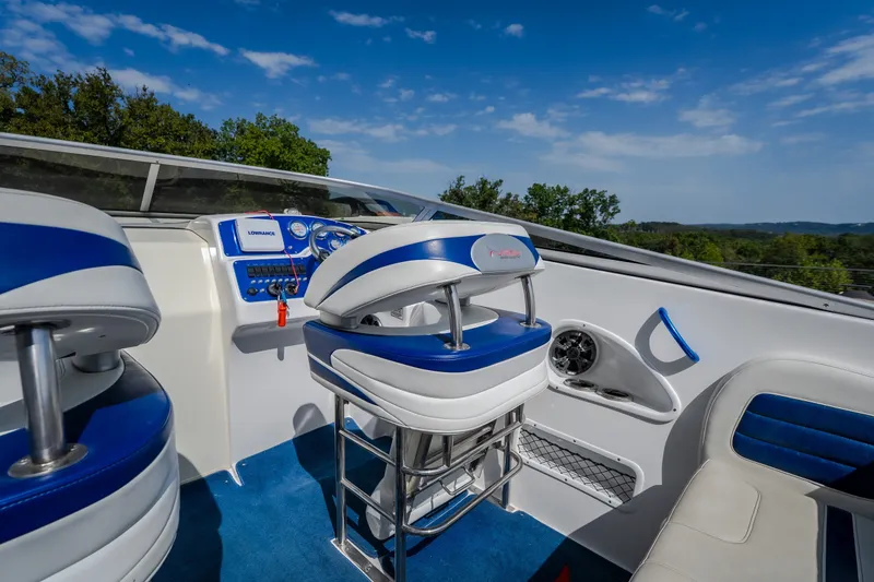 Slide: The Image of Interior of 2012 Nautical NRG 30 boat with blue and white seating, dashboard, and controls. - 12