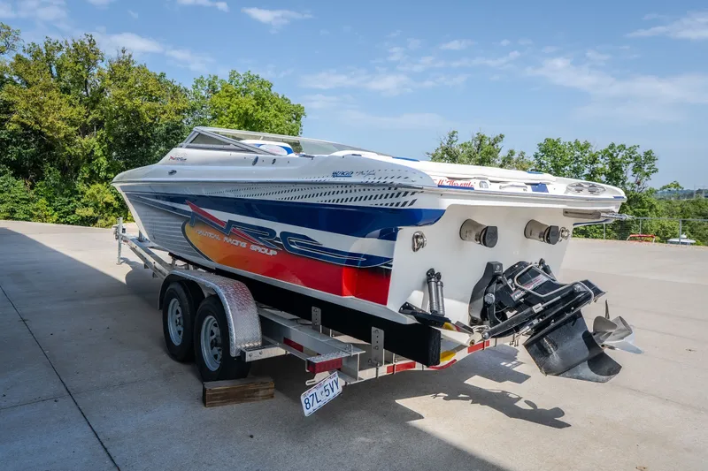 Slide: The Image of Nautical NRG 30 speedboat on trailer, 2012 model, vibrant graphics, parked outdoors. - 55